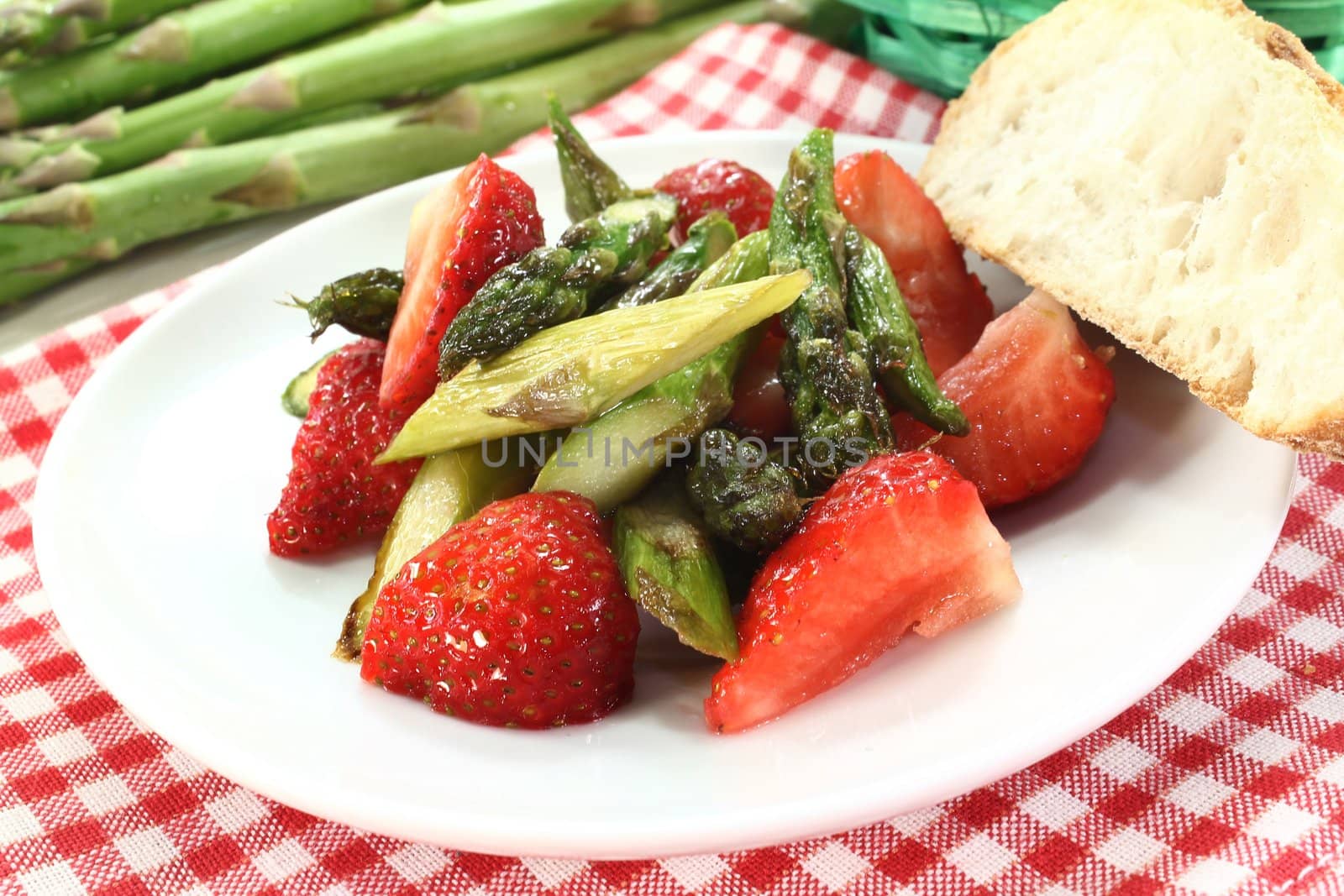 a plate of asparagus strawberry salad with roasted green asparagus