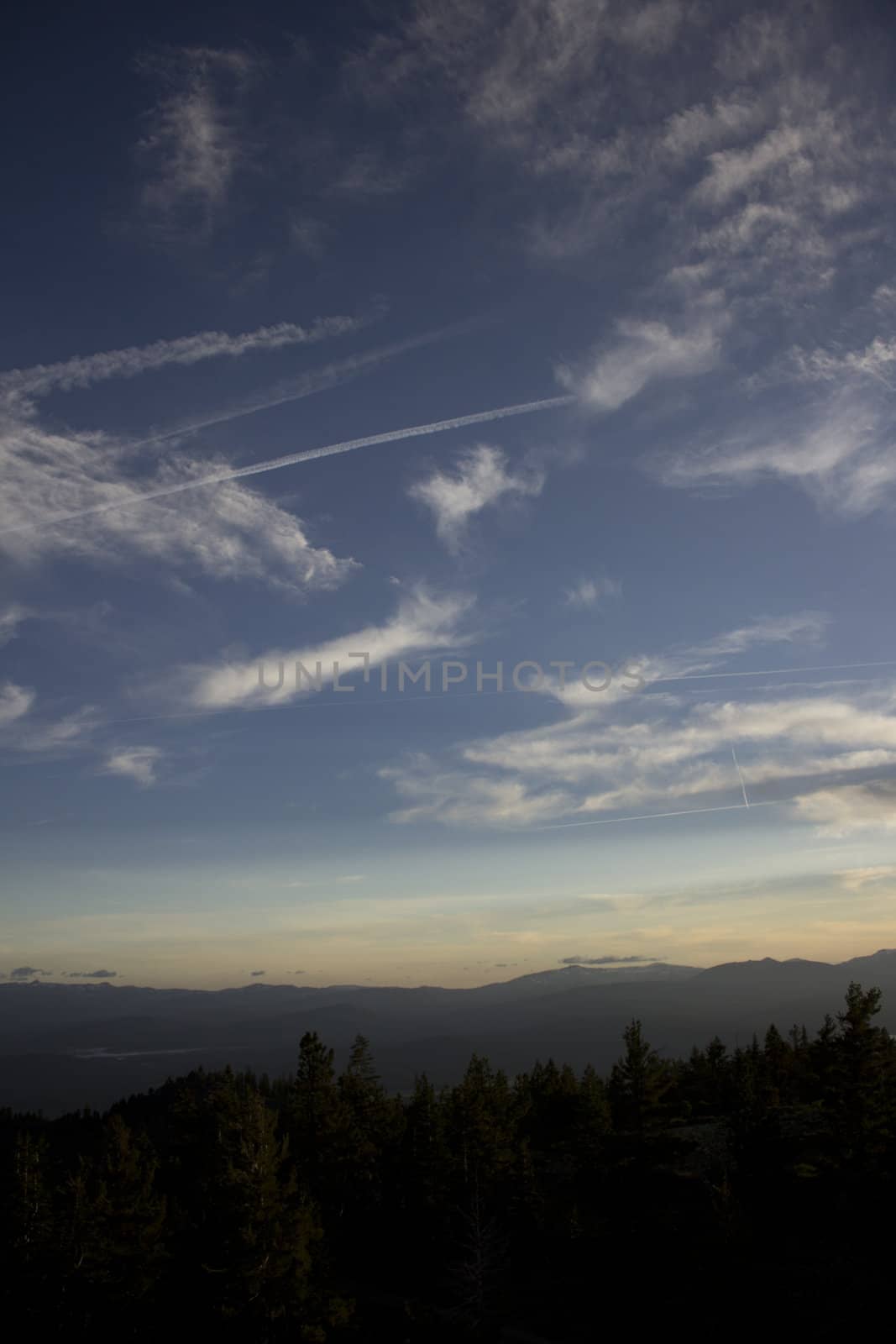 Clouds at dusk in the mountains. dark mountains and a bright blue sky.