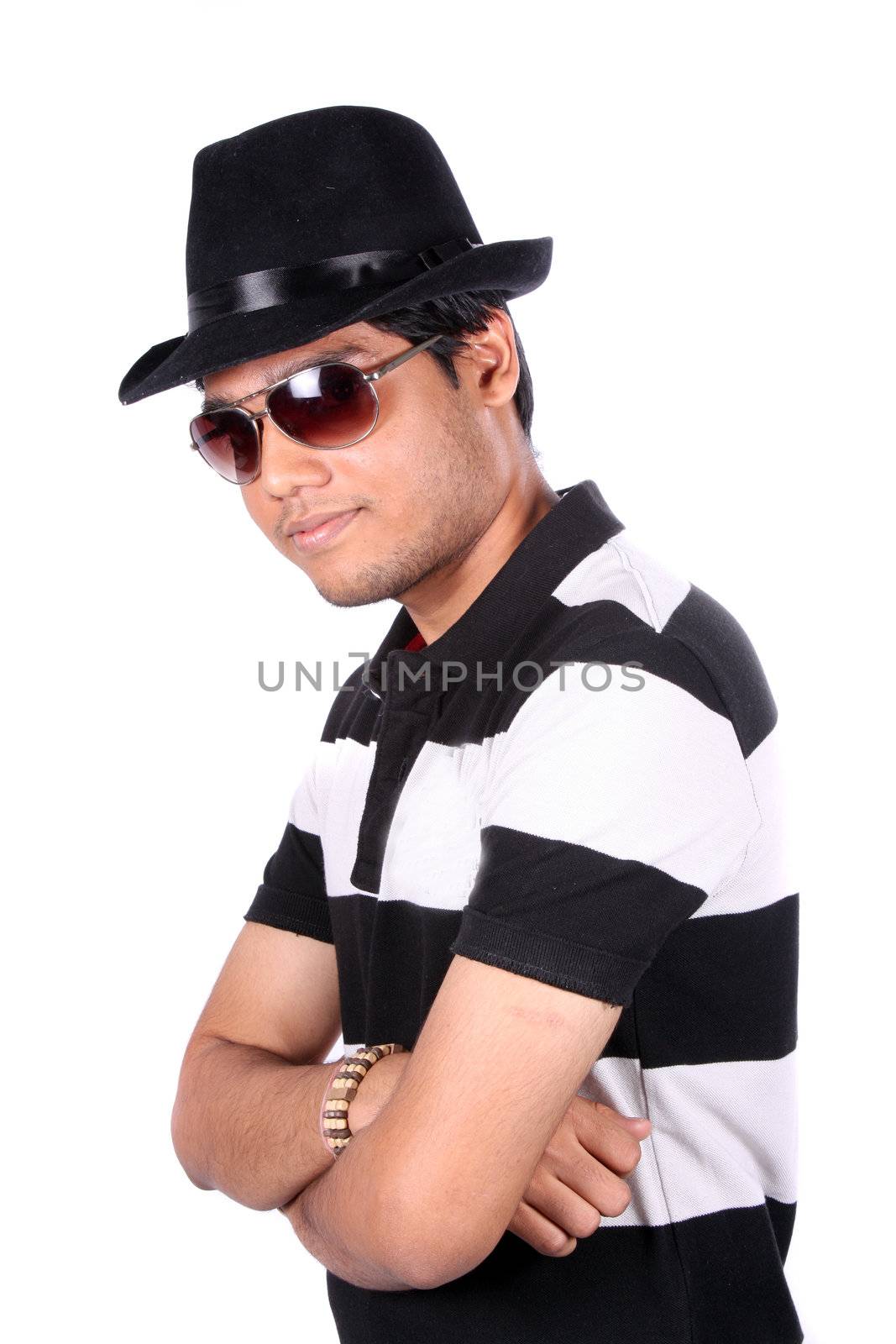 A stylish Indian guy wearing a hat and sunglasses, on white studio background.