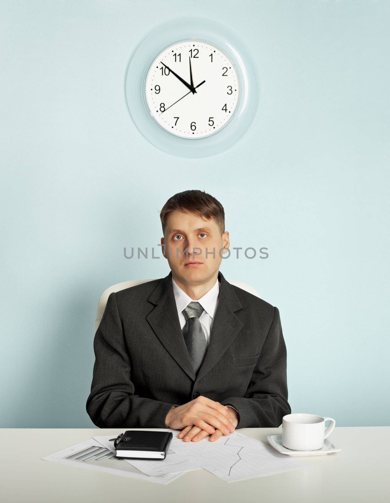 Businessman sitting in an office at the workplace - waiting