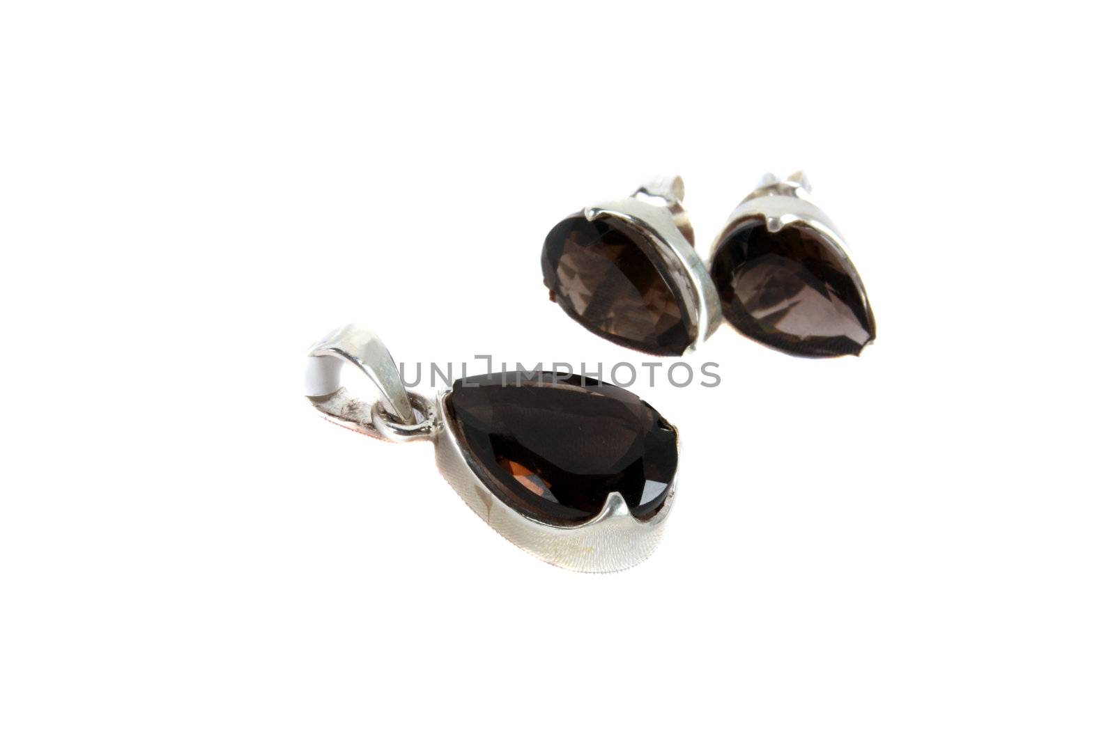 A jewelery set of pendant and earrings made of smoky quartz gemstones, isolated on white studio background. Focus on Pendant