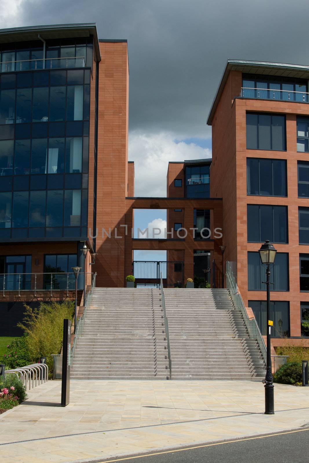 A pavement leads to a set ot steps with hand rails to an accomodation complex.