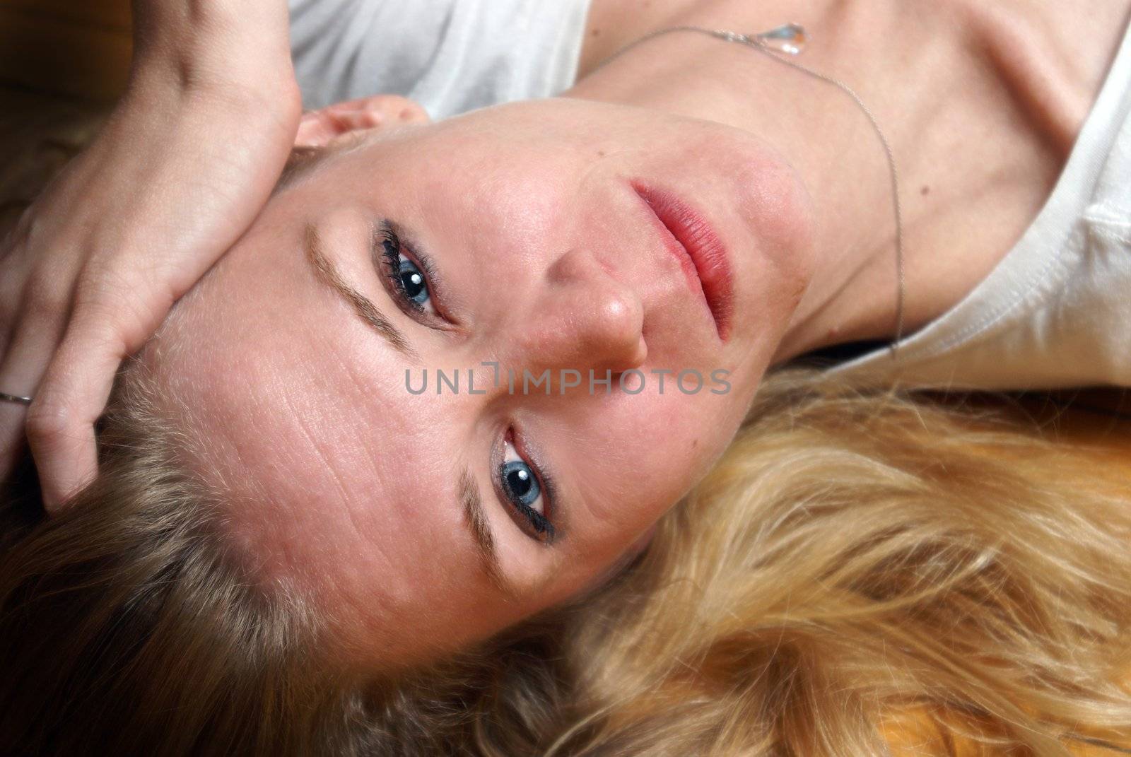 A woman lays on her back while on the floor.