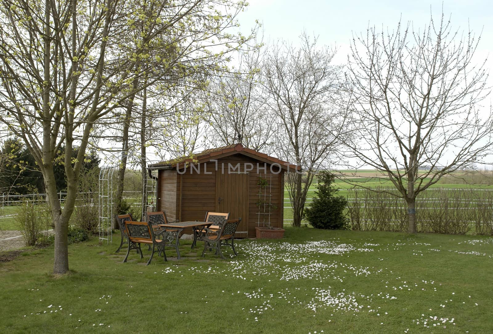 idyllic summerhouse and garden furniture at spring time