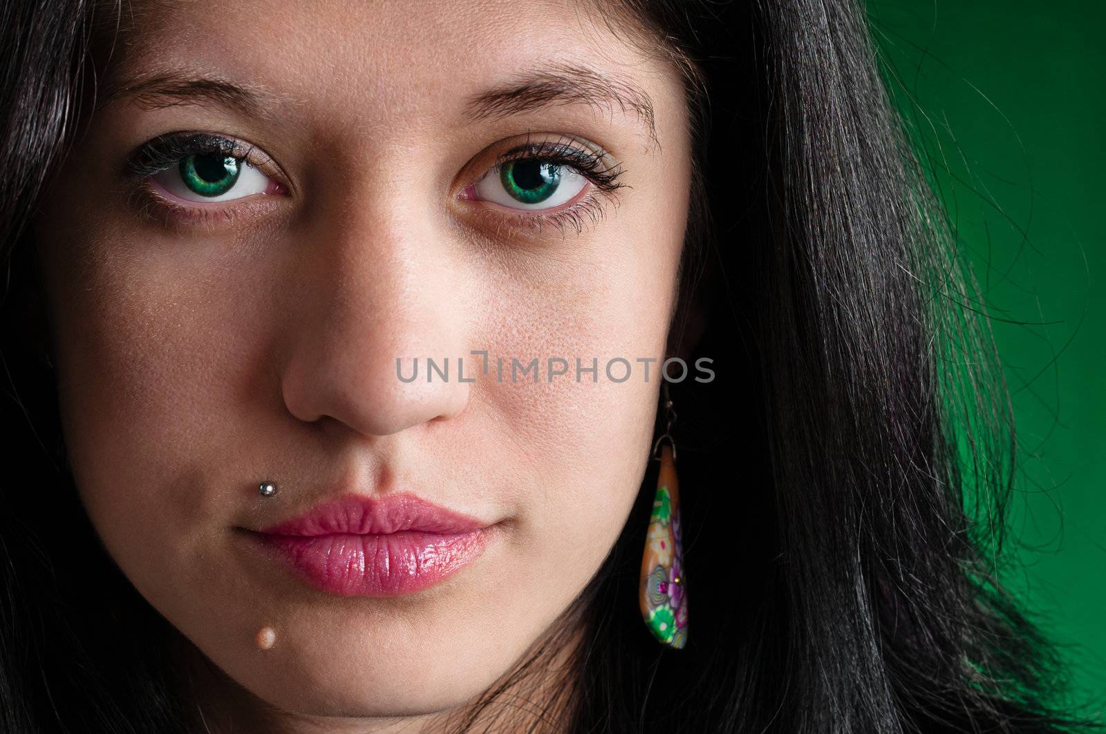 Female face highly detailed close up on green background