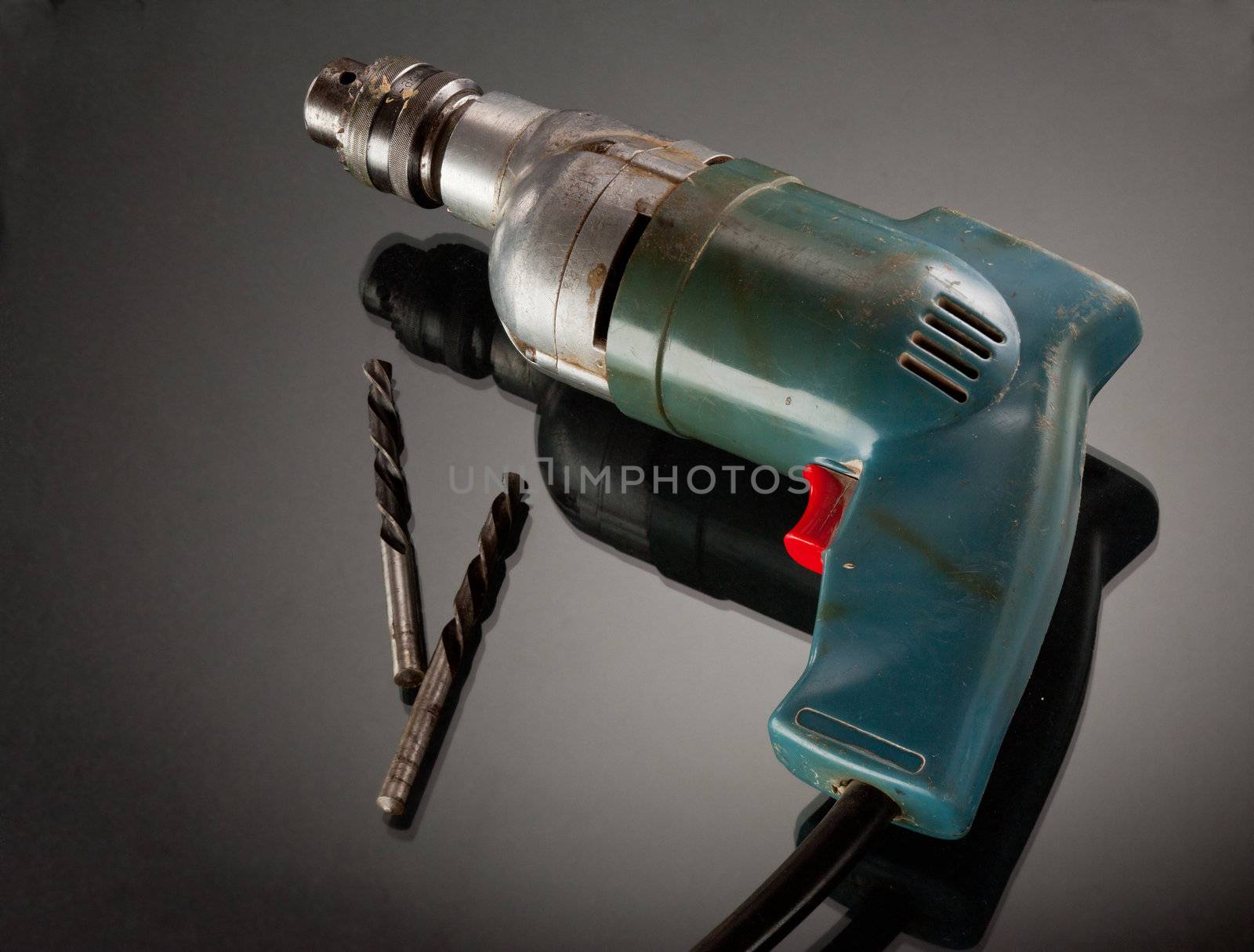 old styled used drill with auger on glassy reflective background