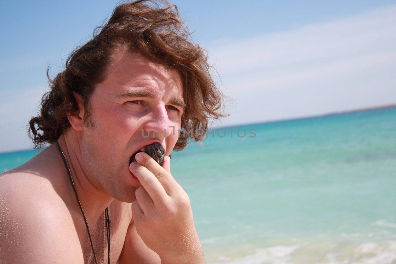 man eating on the beach on vacation