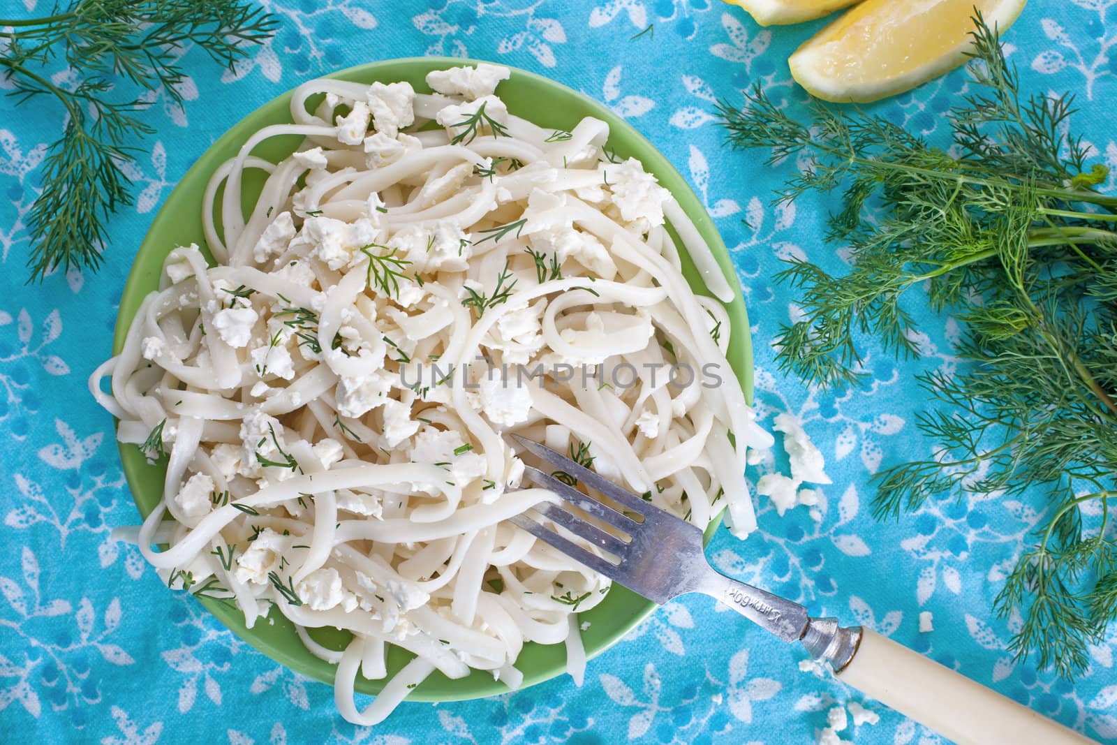 Pasta with cheese and greens on a floral tablecloth