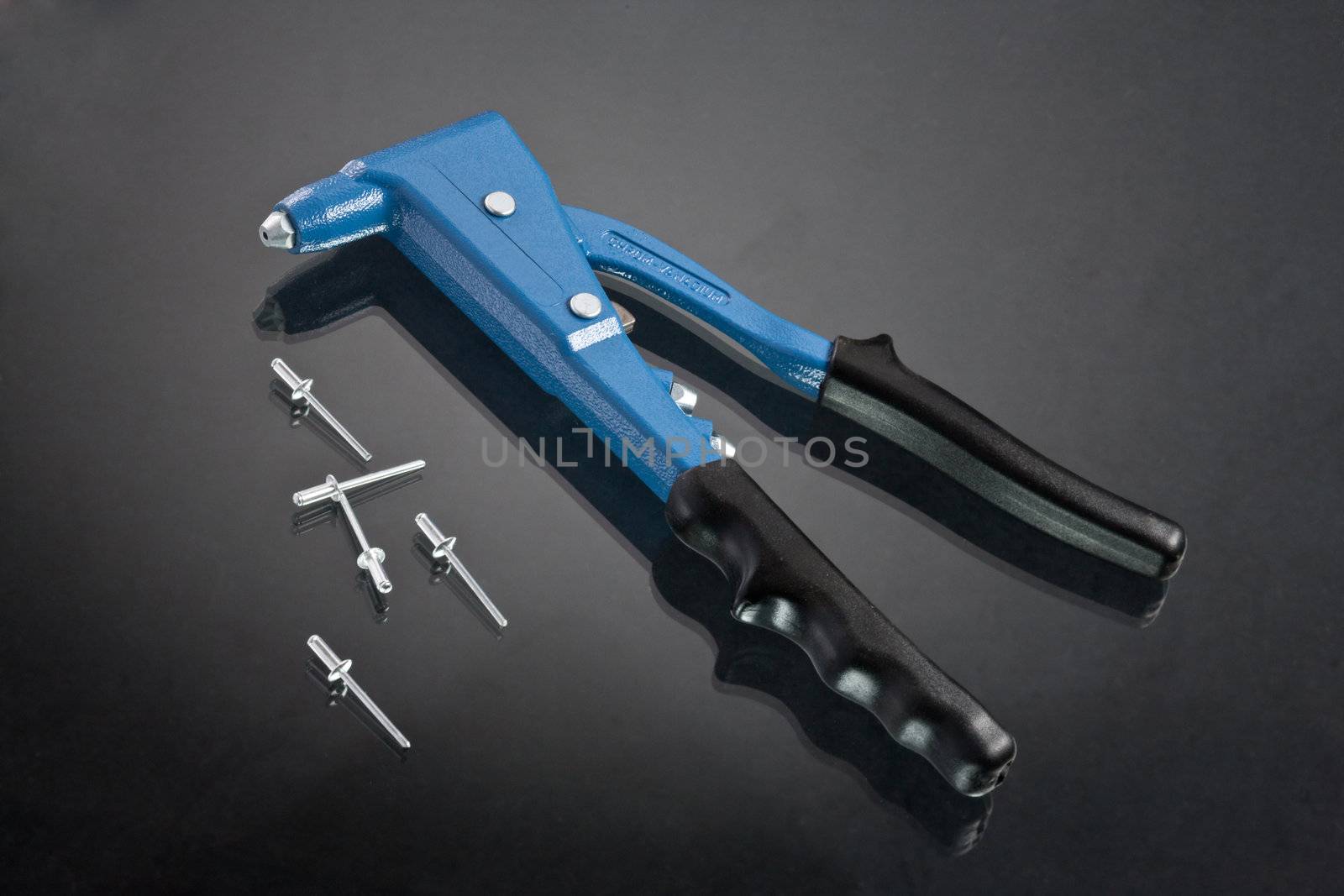 hand riveting tool over glassy dark background