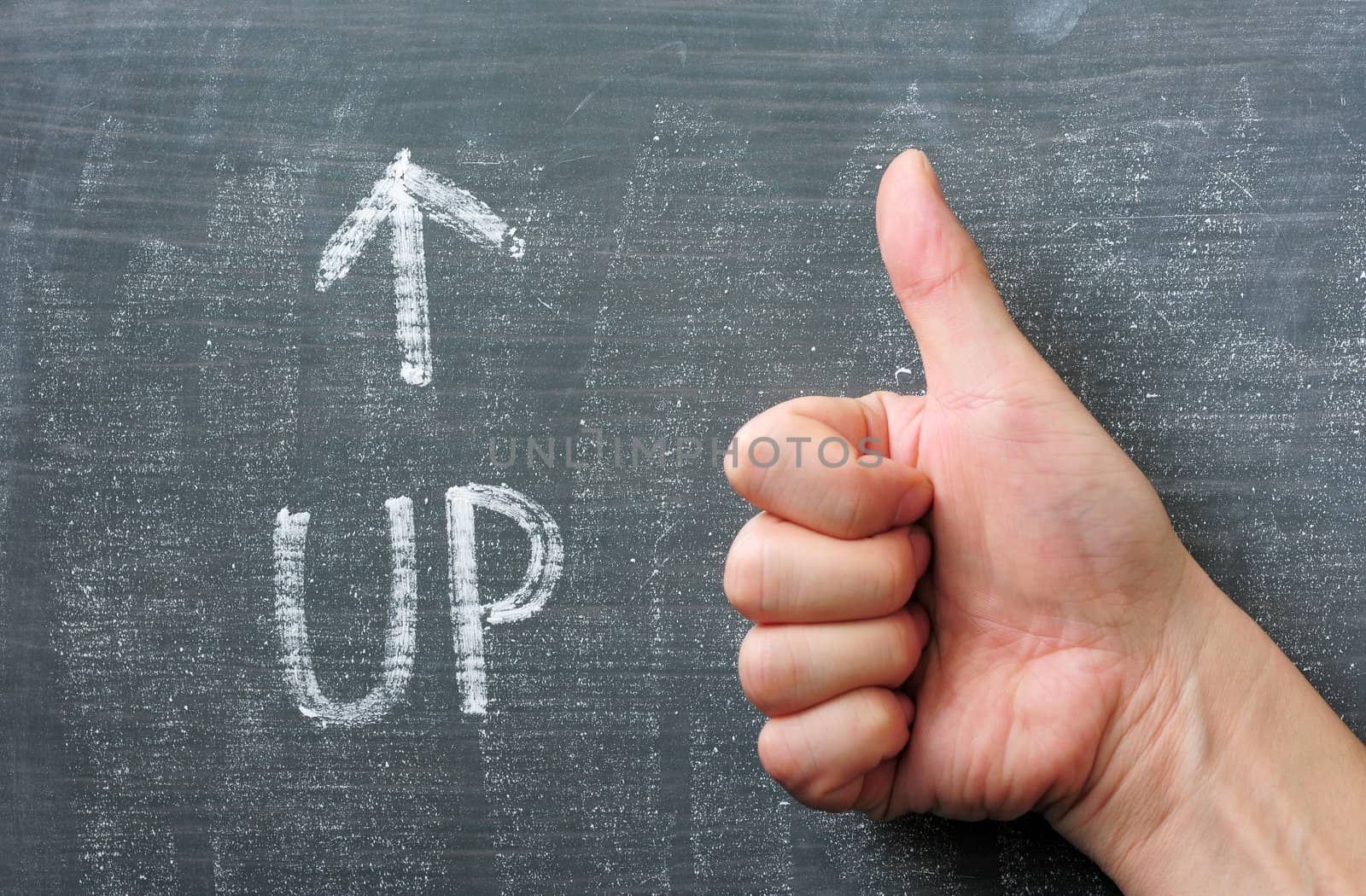 Up - word written on a blackboard with an arrow and thumb up gesture