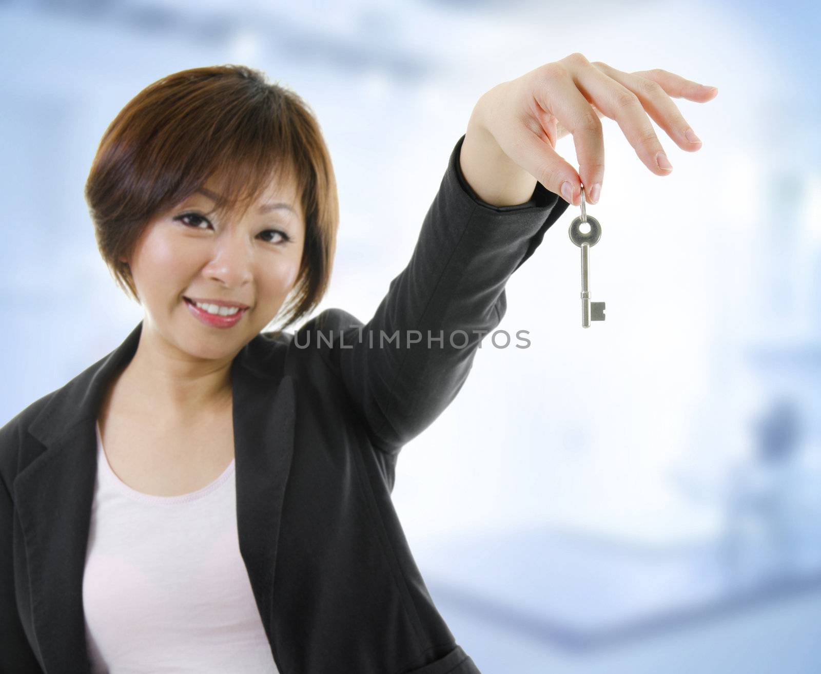 Mid adult Asian woman arms out holding a new key