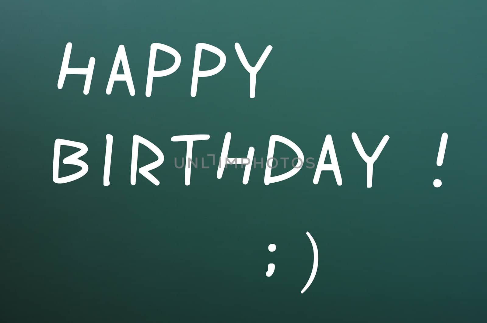 Happy birthday written with white chalk on a blackboard