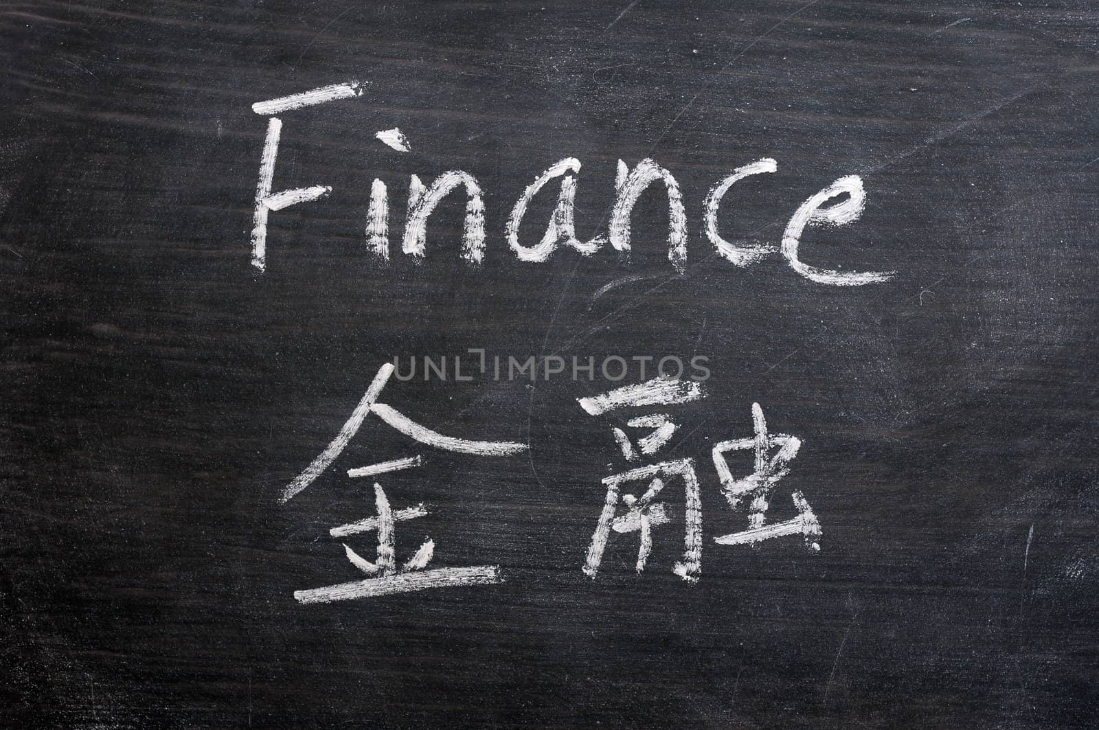 Finance - word written on a smudged blackboard with a Chinese translation