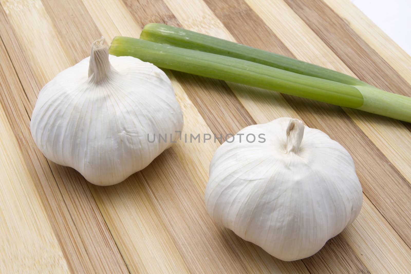 Garlic and green onion closeup on wood background