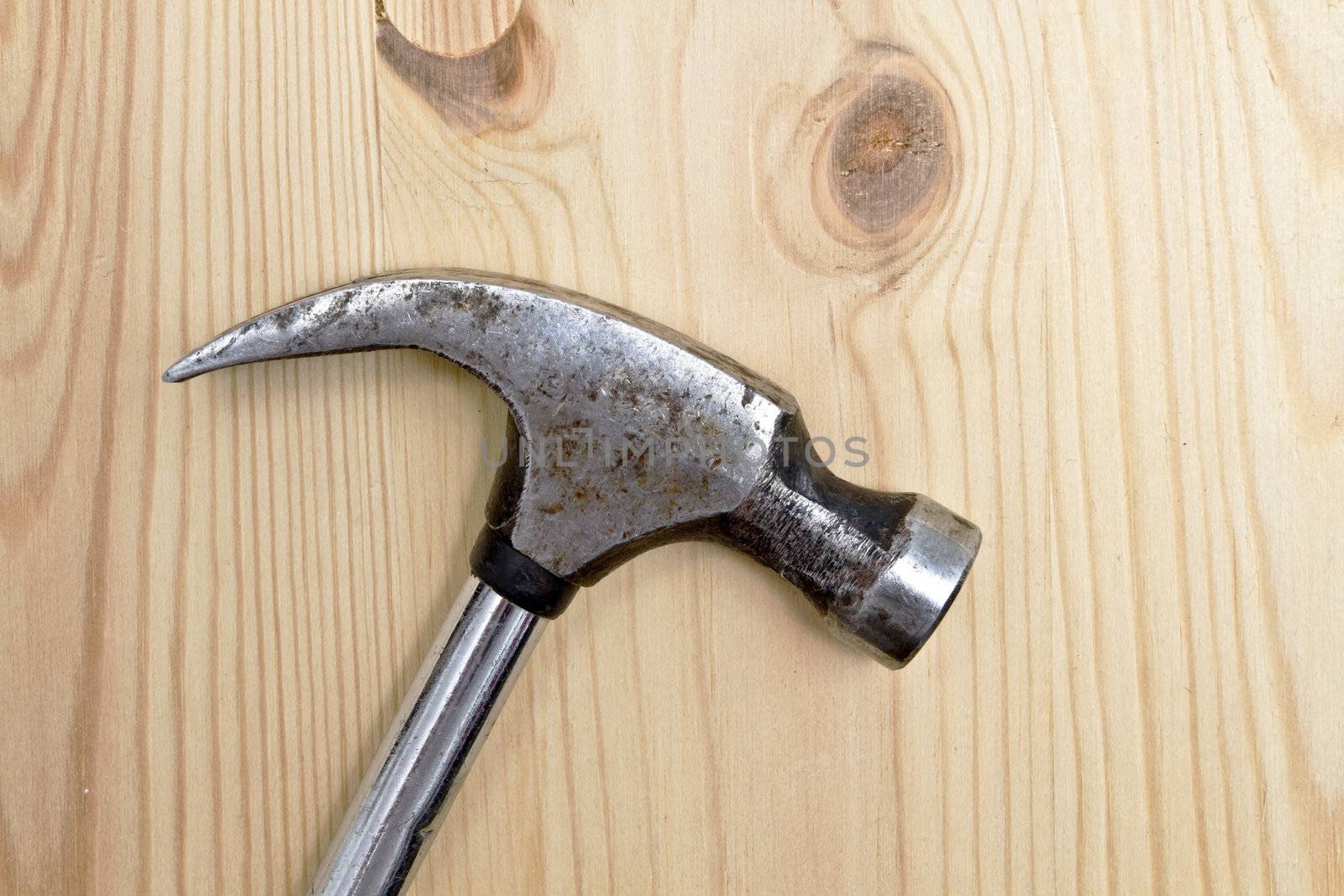 An old Hammer isolated on wood background 
