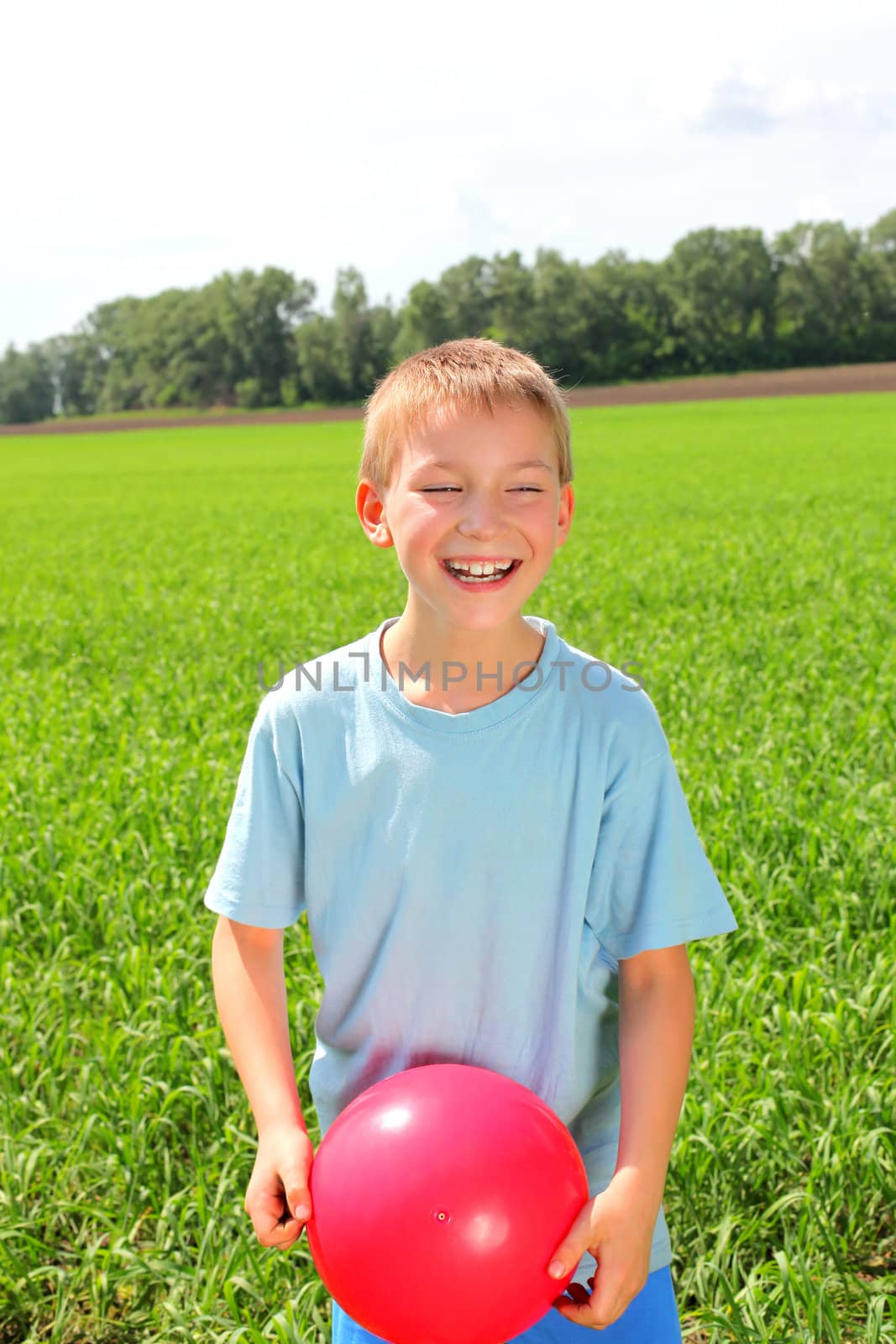 boy with a ball in the summer field