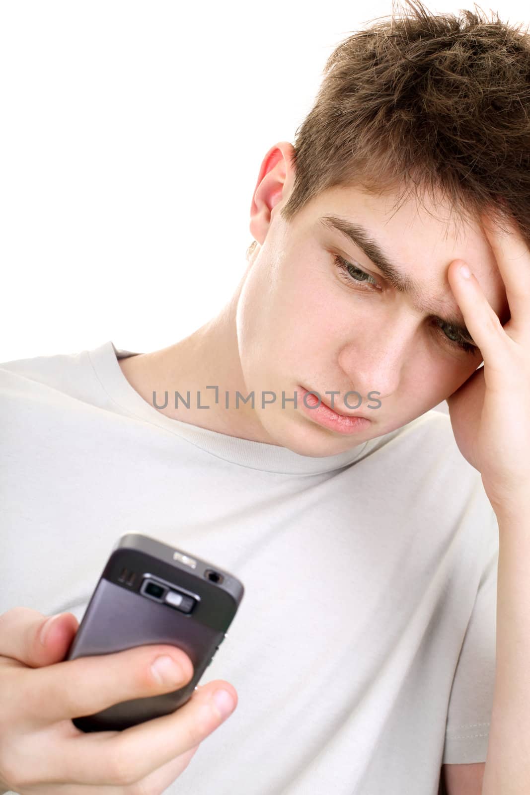discontented young man looking on the mobile phone. isolated on the white