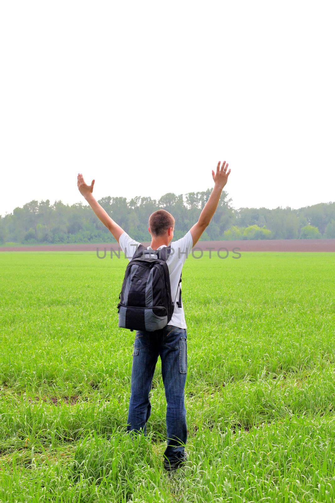 happy teenager with knapsack in the summer field