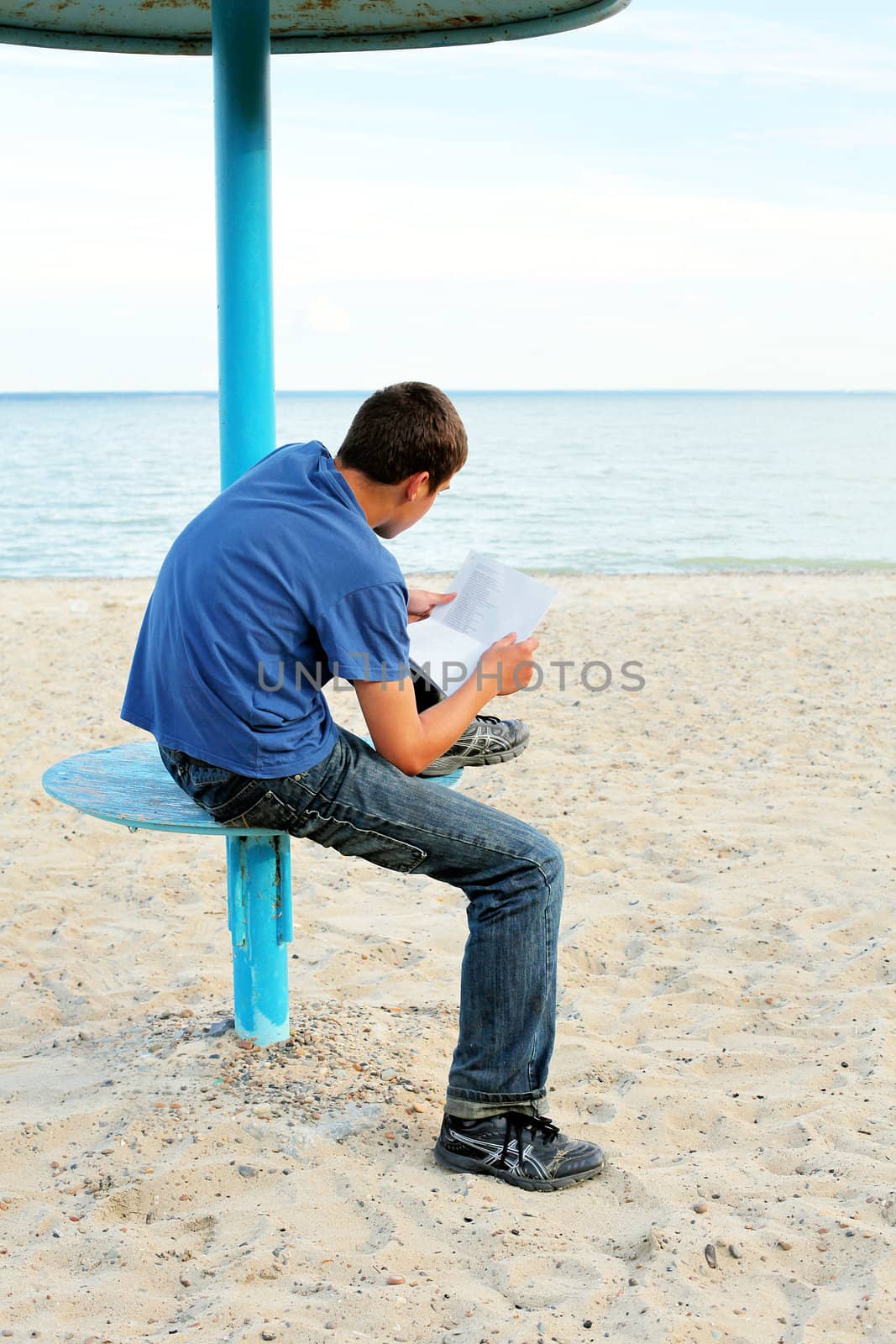 teenager reading letter on the empty beach