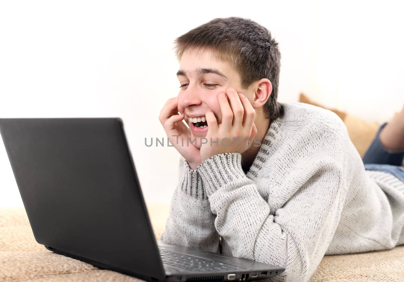 happy young man with notebook on sofa