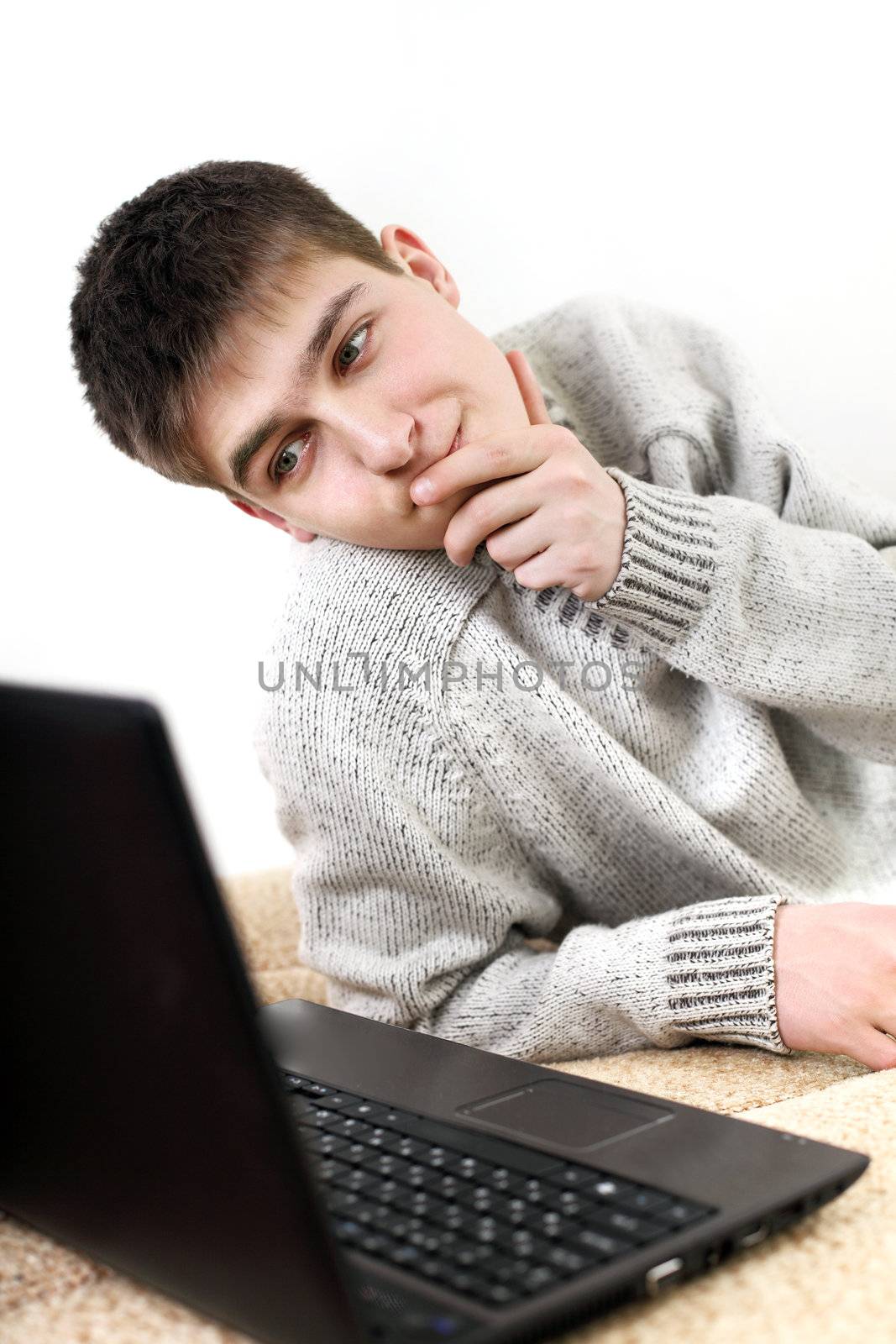 serious teenager with notebook working in home on sofa