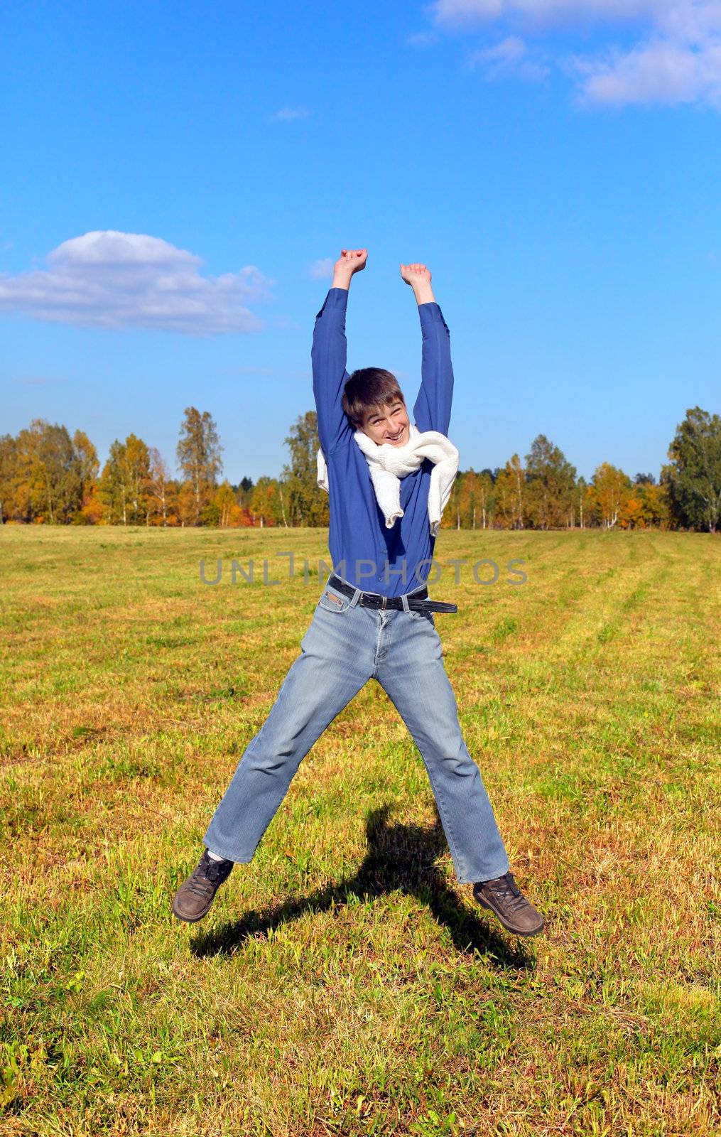 happy teenager jumping in the autumn field