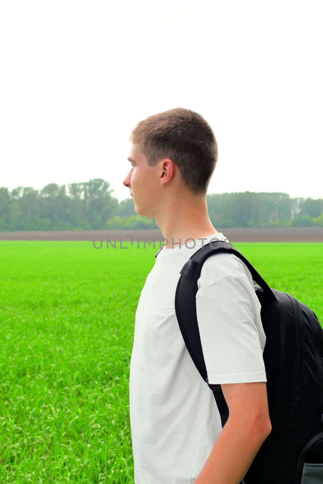 teenager with knapsack in the summer field