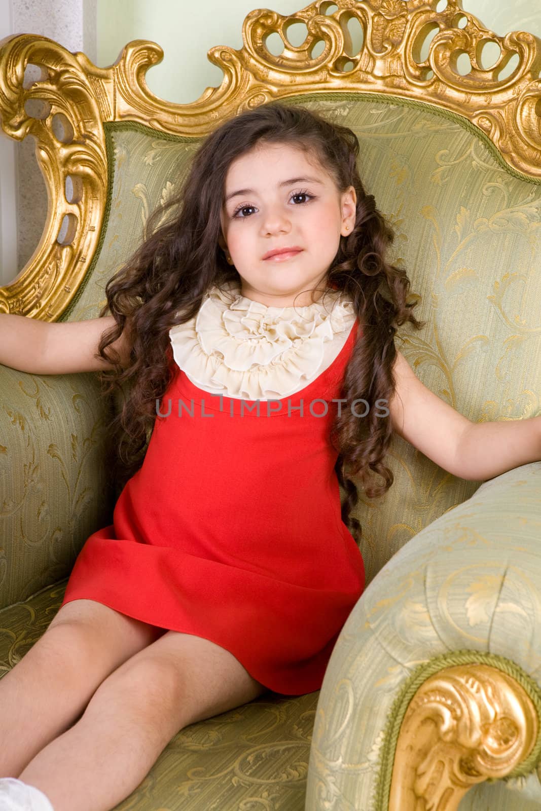 small girl with long hair in the armchair