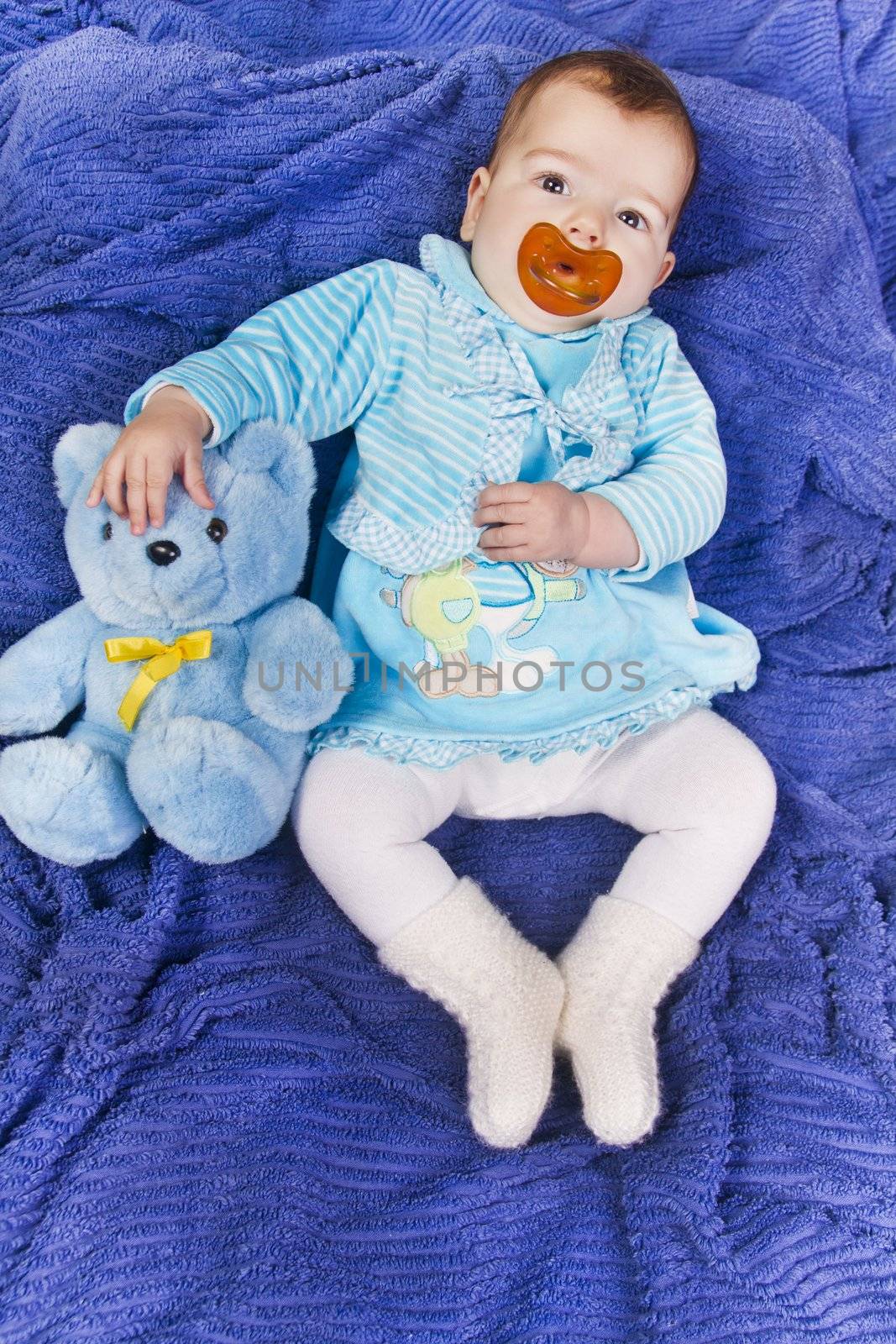 View of a newborn baby with a stuffed toy.