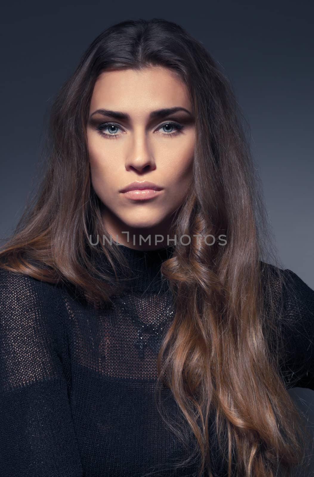 beautiful woman in a black dress in the studio on a dark background