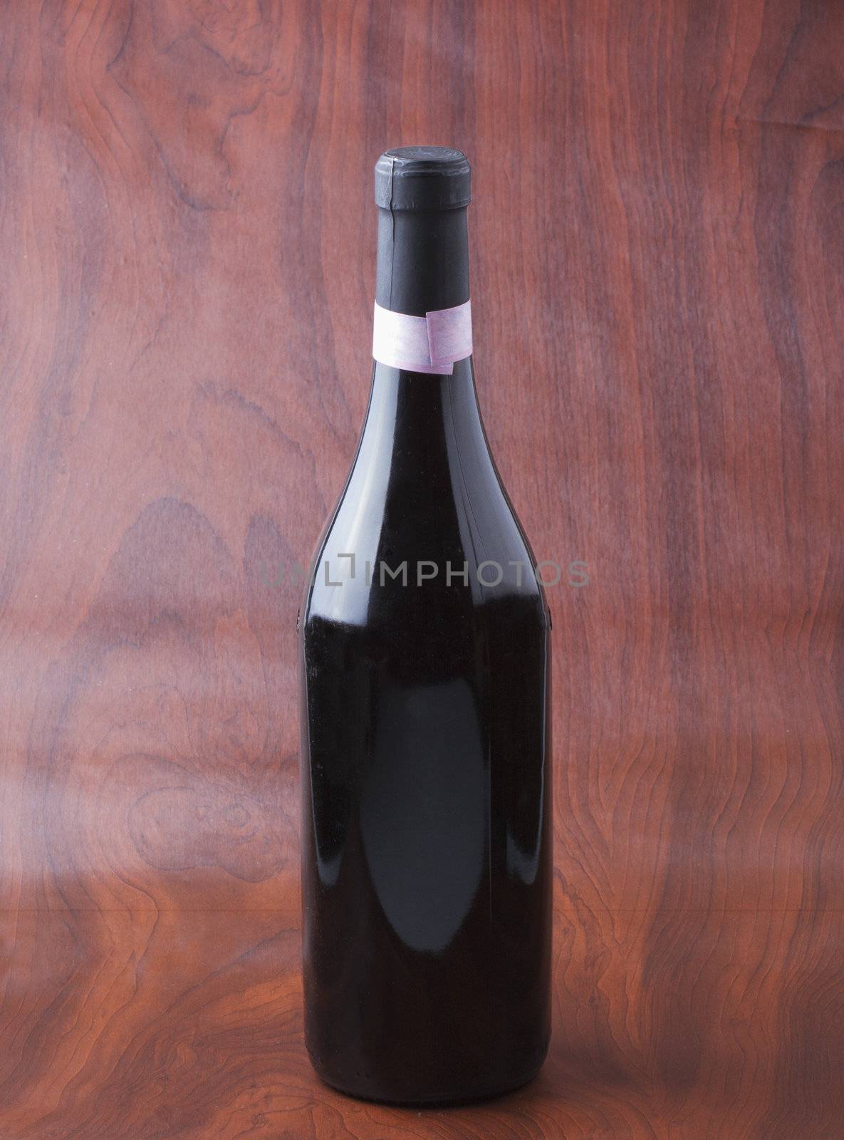 Wine bottle of red wine over wooden background