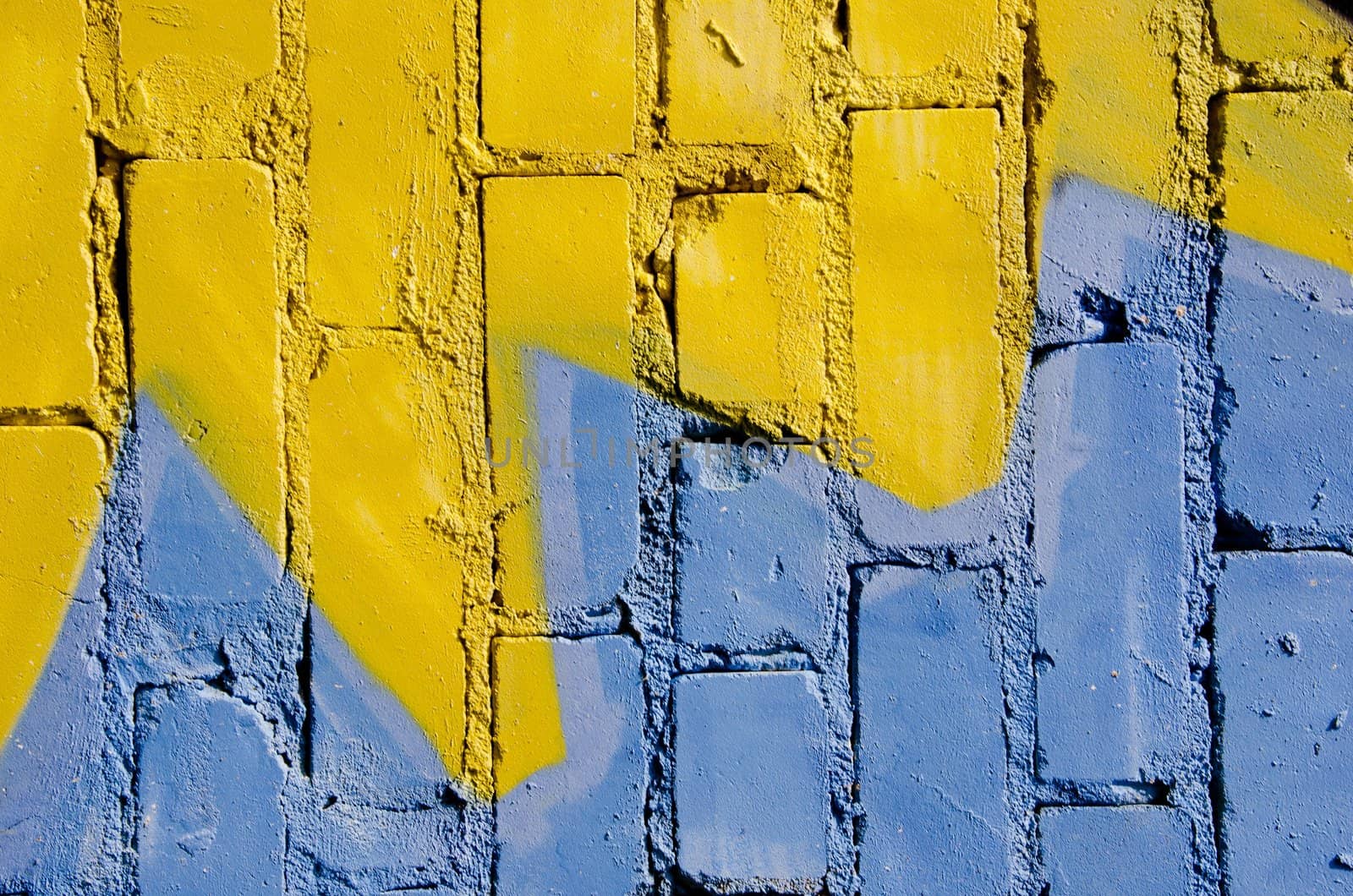 White brick wall colored yellow and blue. Nice background.