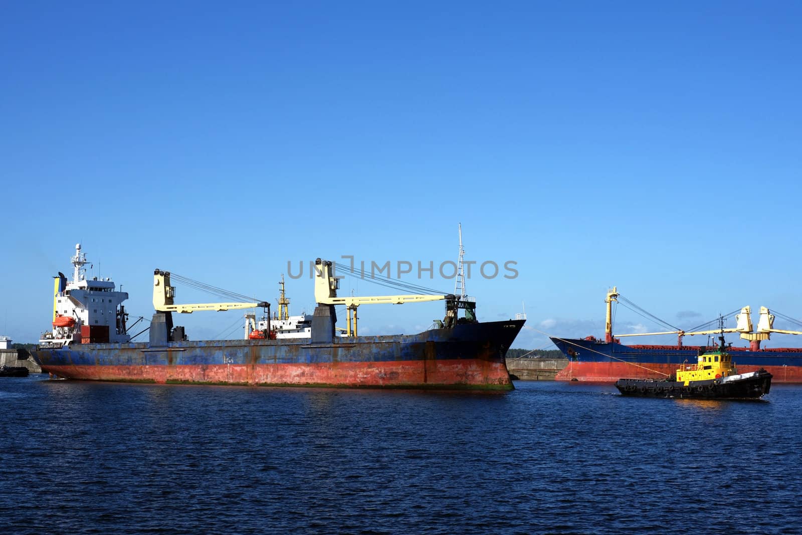 The tow drags the cargoship in harbour