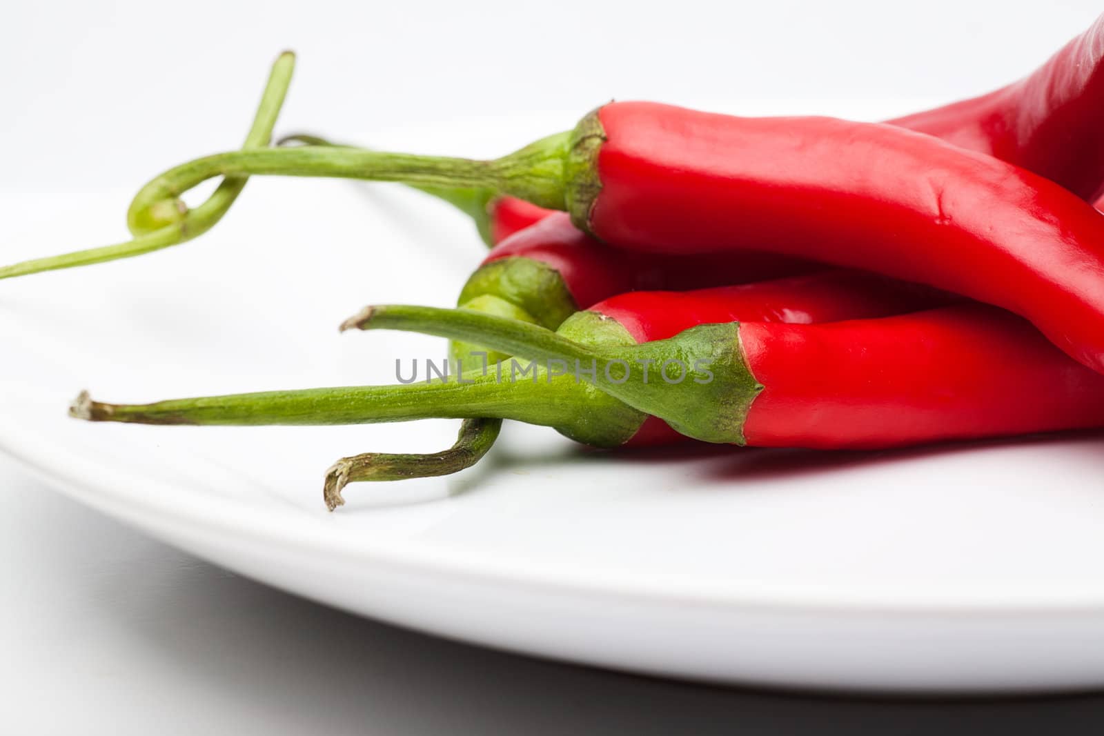 Closeup view of red chili peppers on a white plate