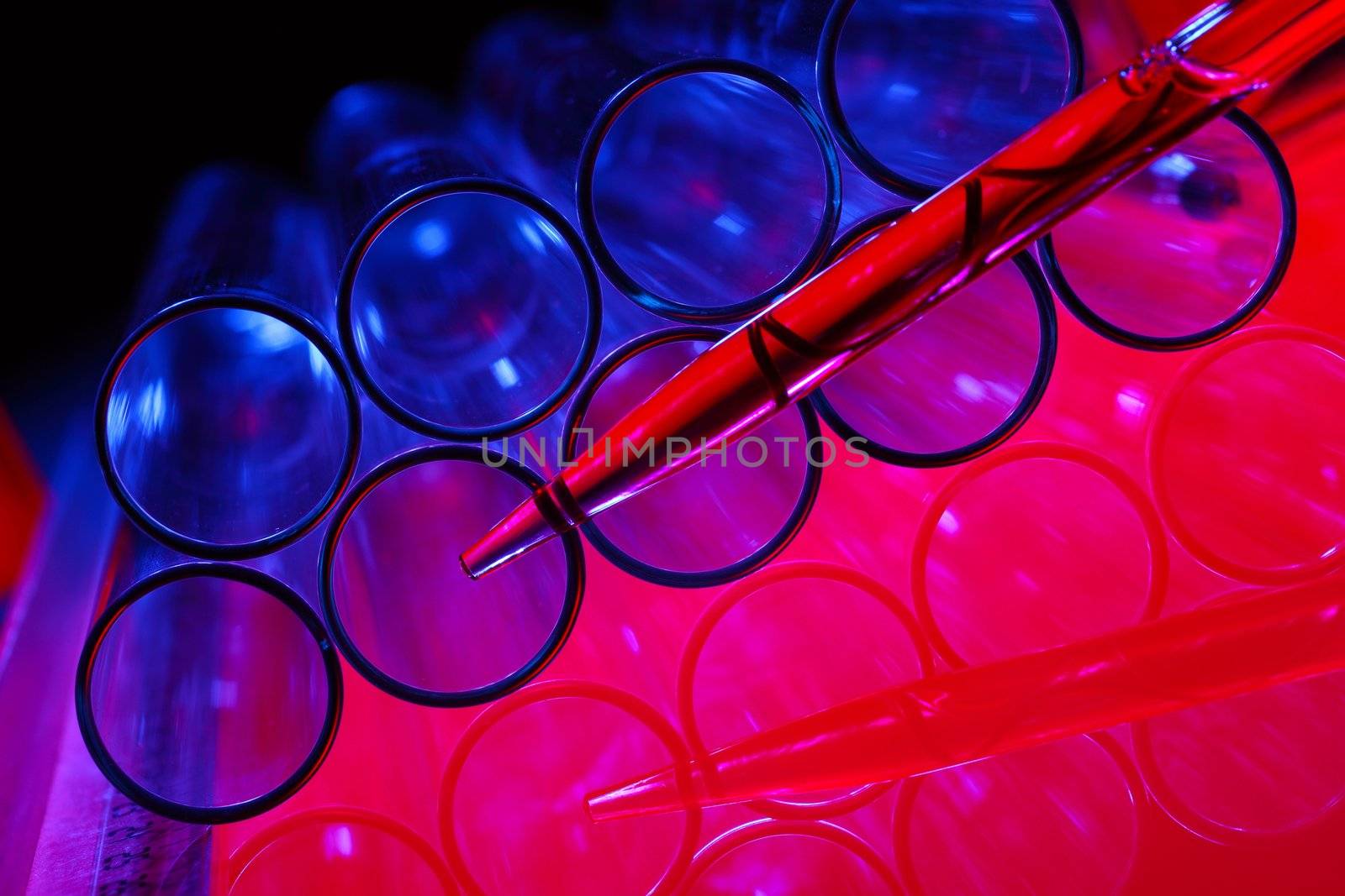 Glass chemistry tubes on a colour background