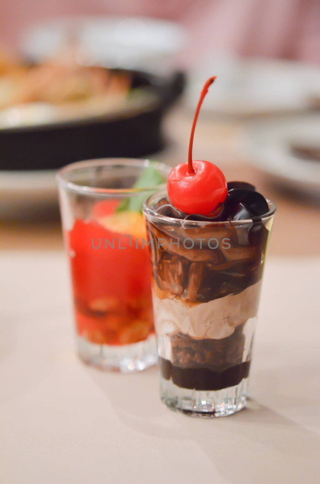 a layered chocolate , garnished with cherries in glass