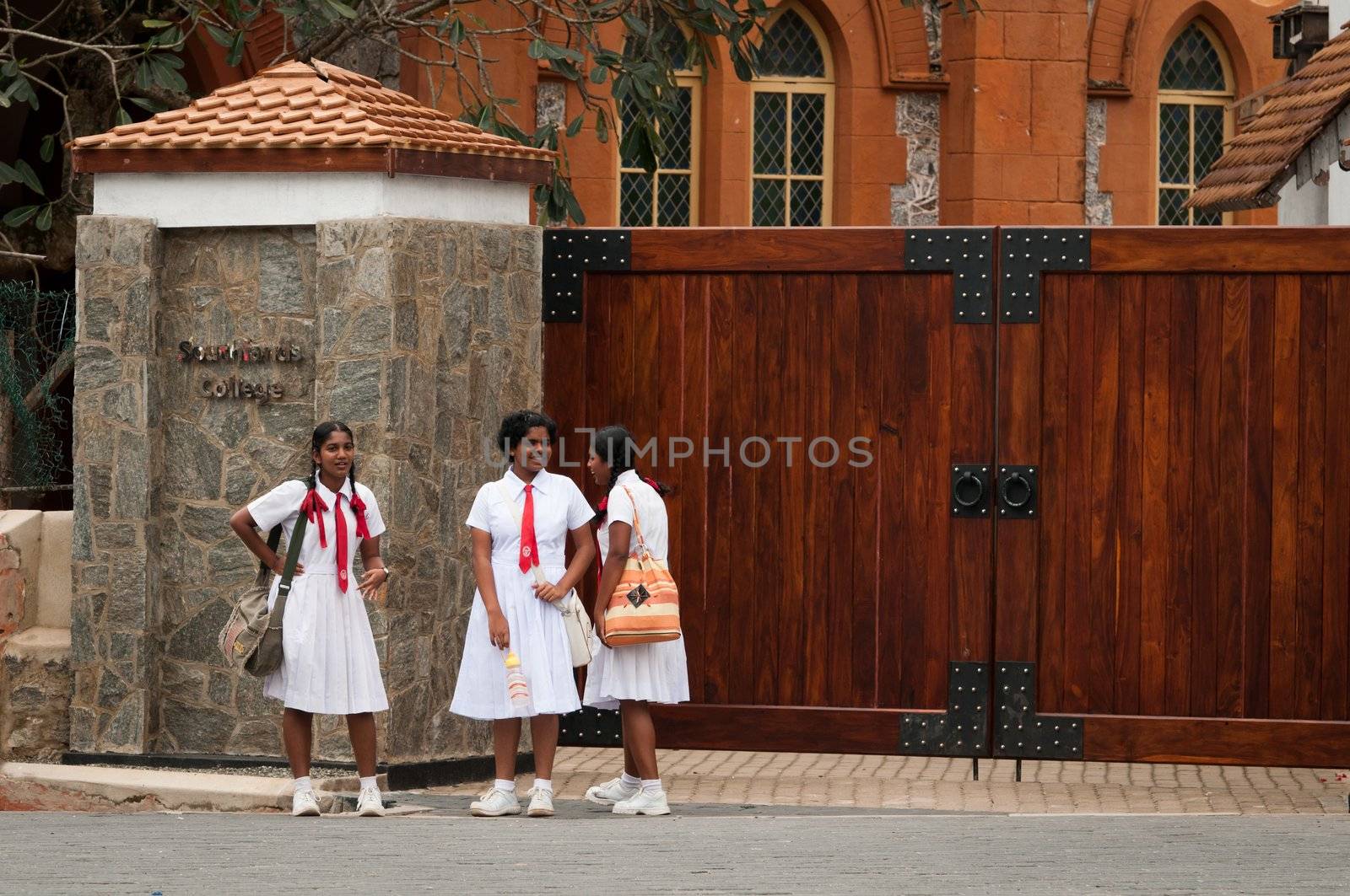 Galle, Sri Lanka, December 15, 2011- Three Sri Lankian students in uniform talk in front of Southlands College
