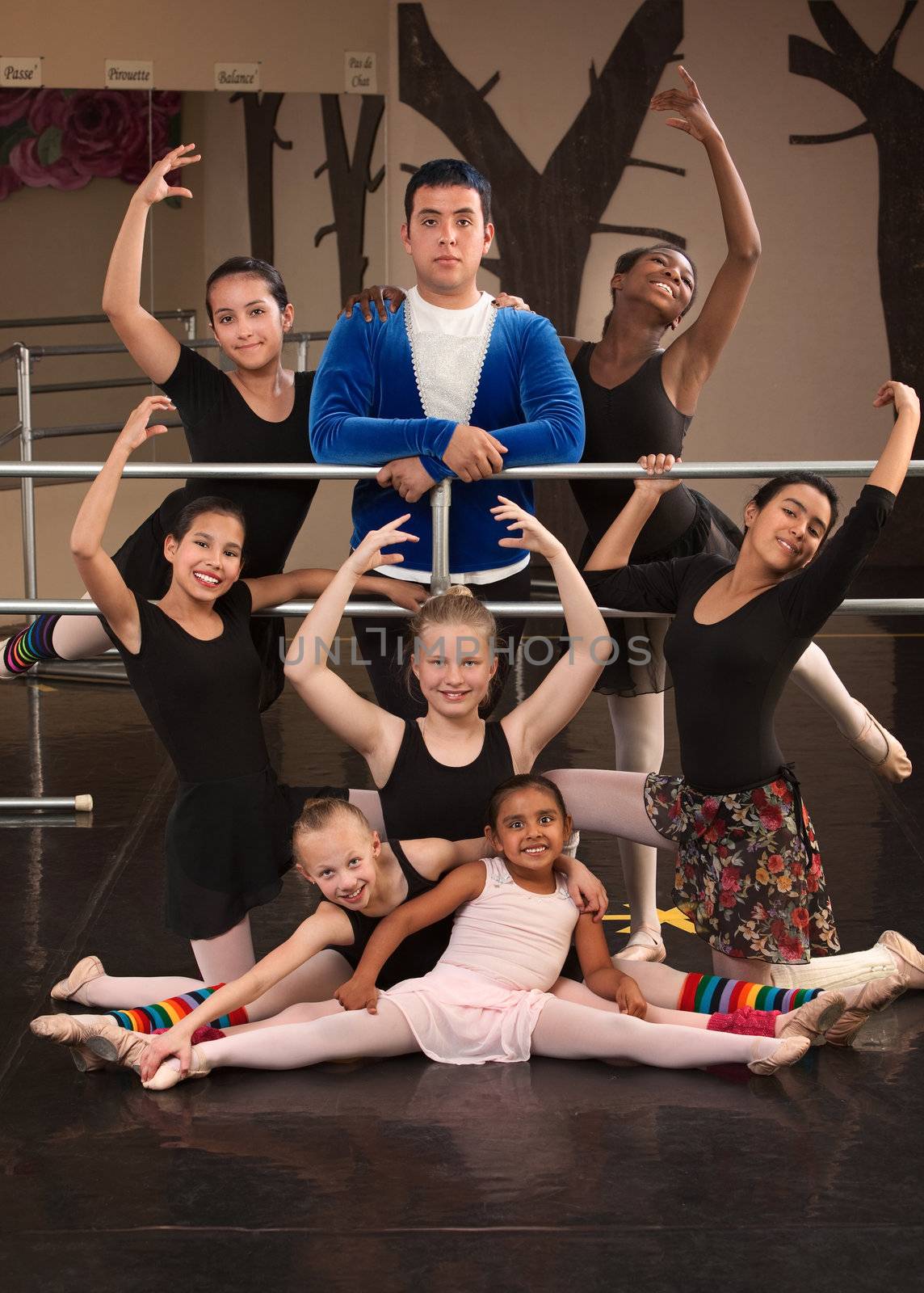 Cute group of girls with male instructor at ballet class