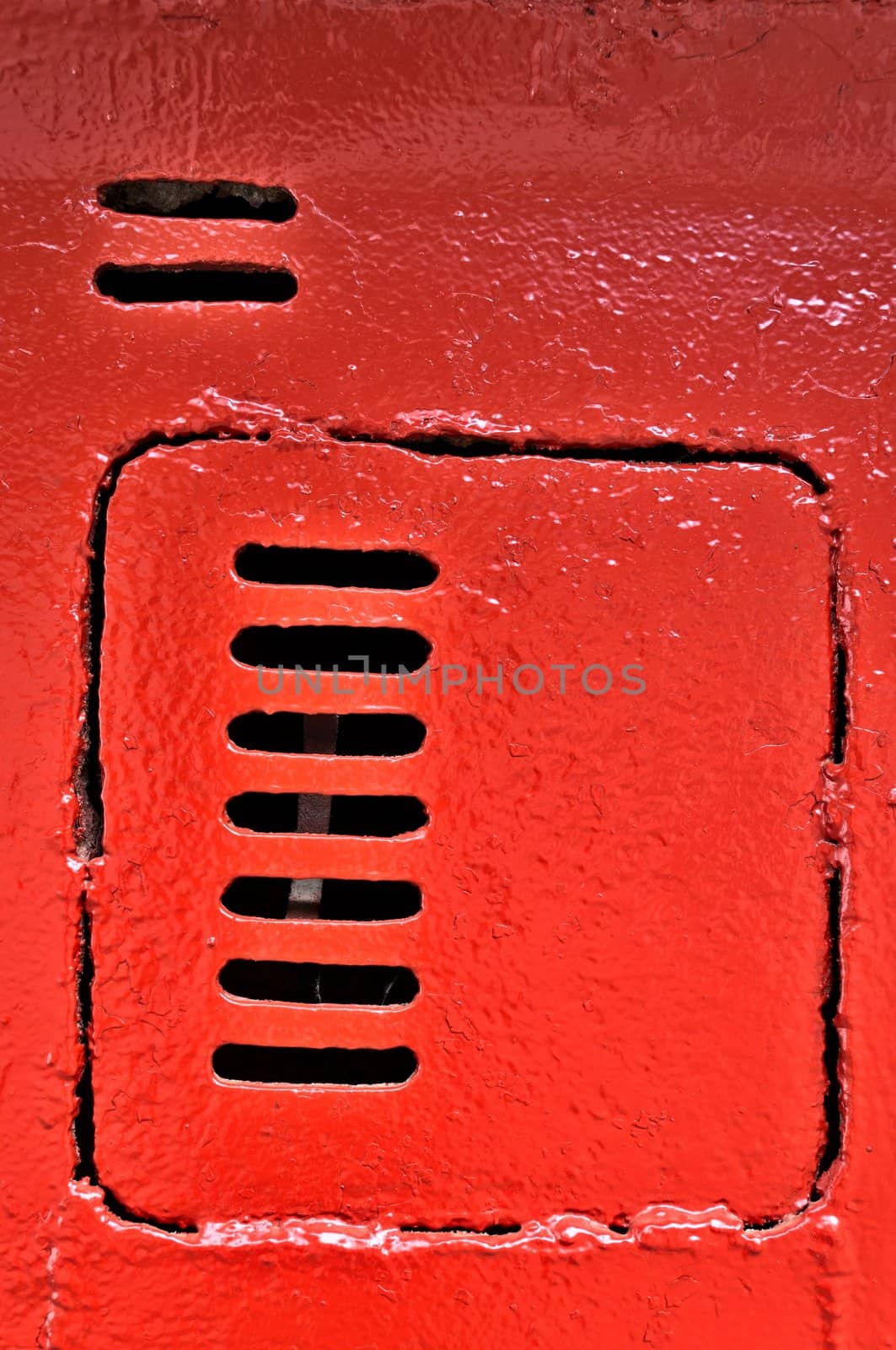 Old metal door with vents, painted with red paint