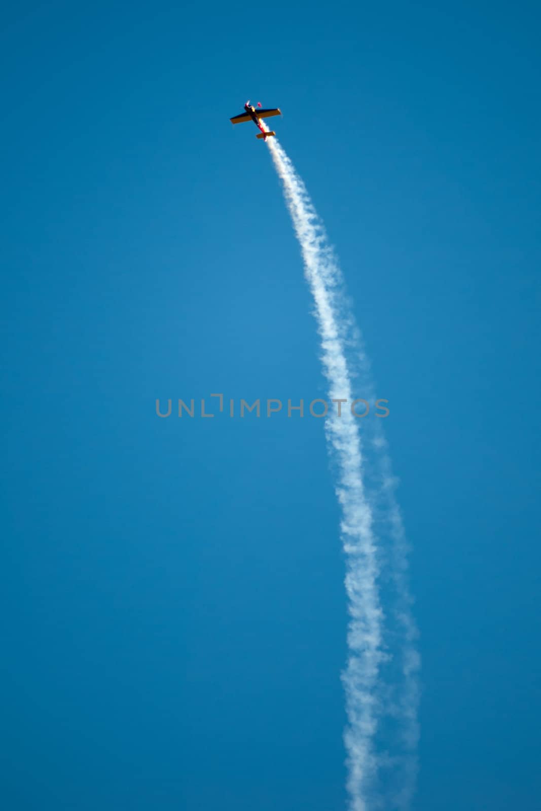 Propeller aerobatics plane in action with a big vapour trail