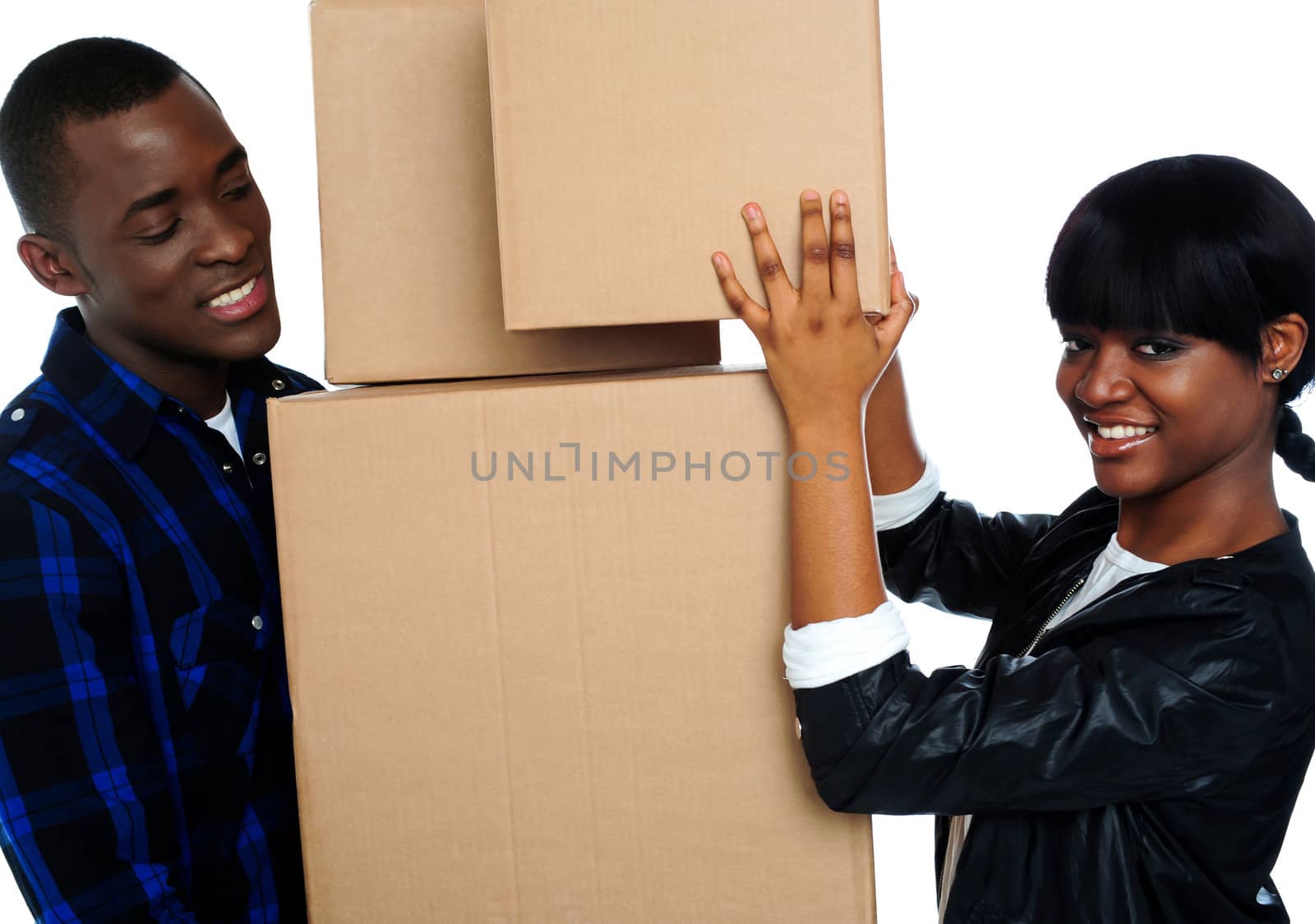 Young couple holding and moving boxes by stockyimages