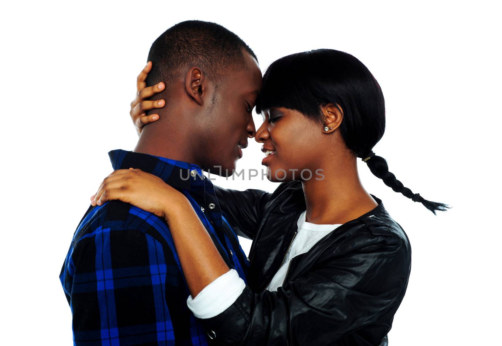 Beautiful young female about to kiss her boyfriend against white background