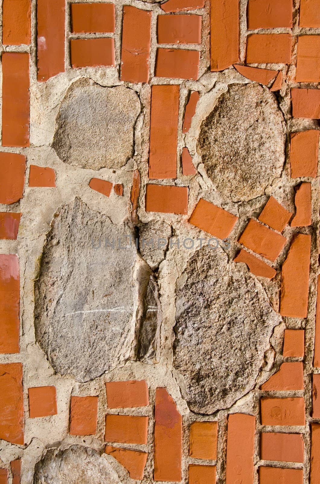 Intresting old wall fragmentmade of red bricks and stones. Architectural background.