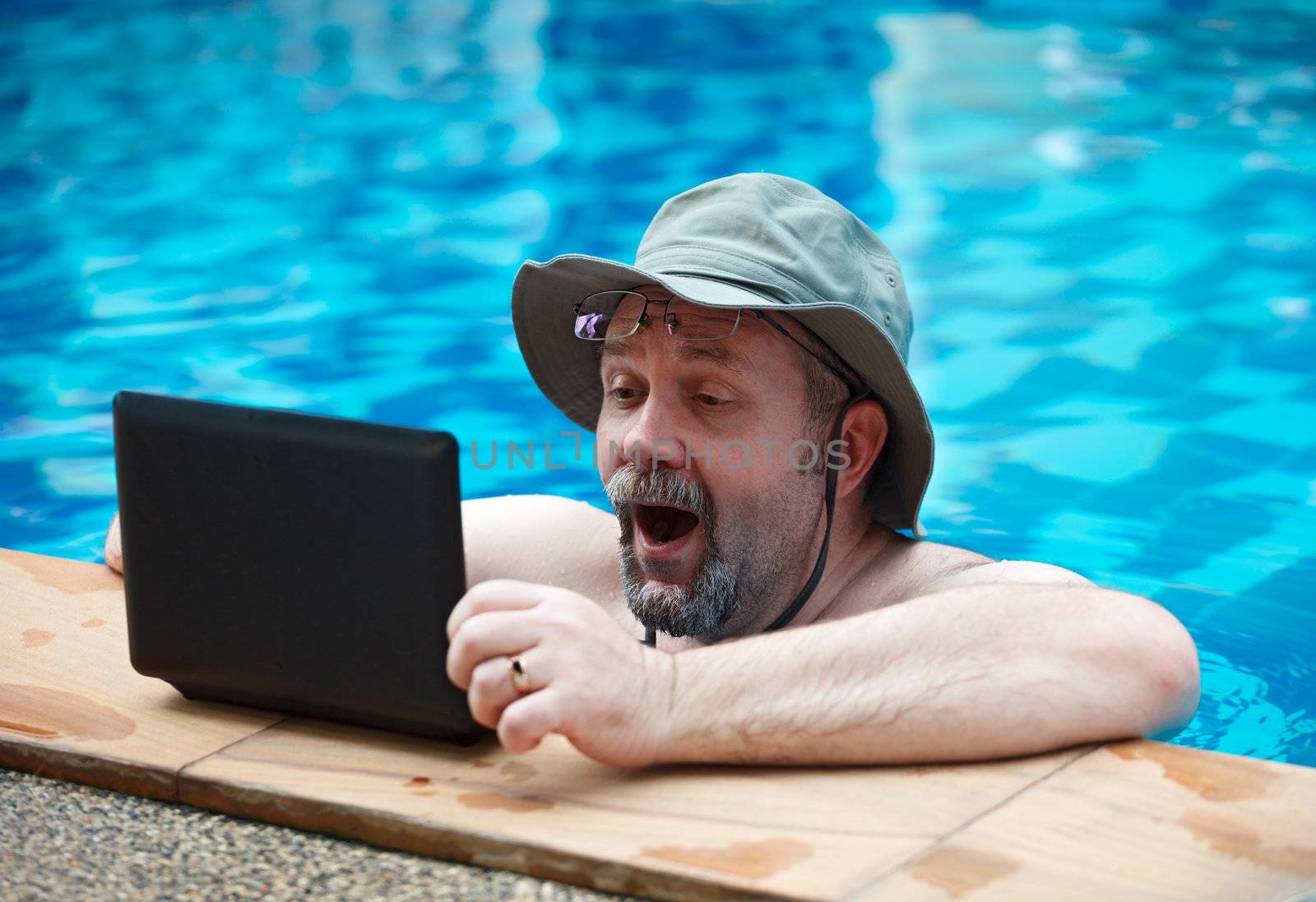 The man in the pool viewing the latest news on the Internet