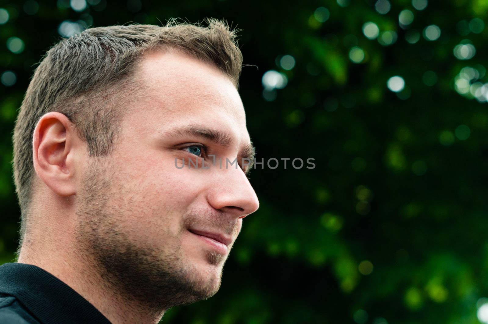 Attractive man head profile with green tree on background