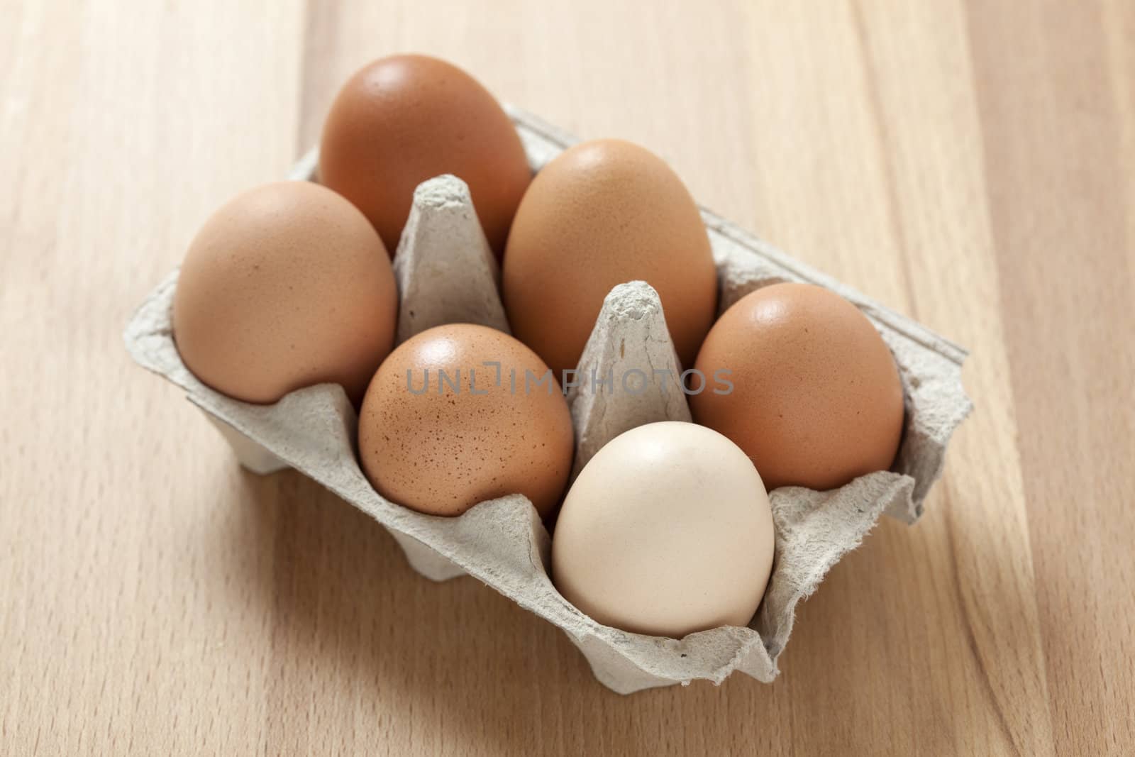 Six  brownish eggs in carton box