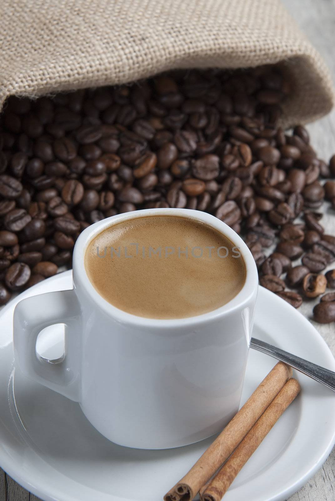 Still life about coffee with a delicious  espresso and some coffee beans and cinnamon.