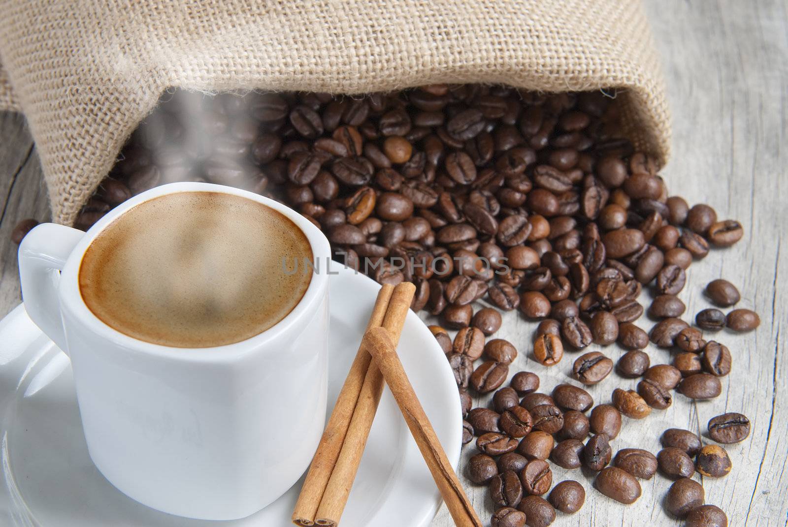 Still life about coffee with a delicious  espresso and some coffee beans and cinnamon.