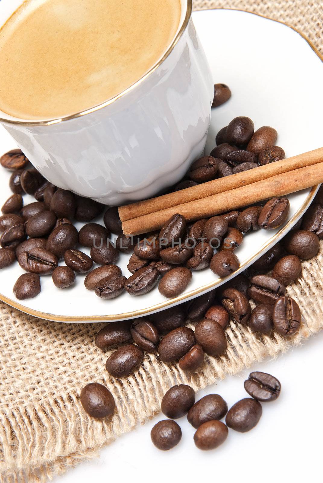 Still life about coffee with a delicious  espresso and some coffee beans and cinnamon.