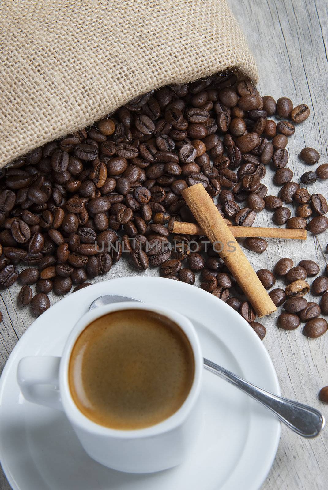 Still life about coffee with a delicious  espresso and some coffee beans and cinnamon.